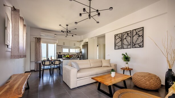 Una sala moderna con sofá, mesa de centro y comedor.