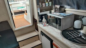 A compact kitchen with a microwave, toaster, and sink. - Virginia Bed and Boat (Syracuse)