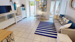 A living room with a TV, sofa, and dining area. - Calm 2P Flat with A/C, Large Terrace, Near Beach and Shops in Central Menton (Menton)