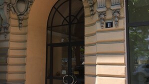 An ornate building entrance with a large arched doorway, a glass door, and a number plaque. - Calm 2P Flat with A/C, Large Terrace, Near Beach and Shops in Central Menton (Menton)