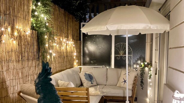 A cozy room with a sofa, a standing fan, and a decorative umbrella. - Calm 2P Flat with A/C, Large Terrace, Near Beach and Shops in Central Menton (Menton)