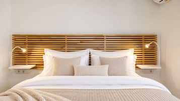 A bed with a wooden headboard, bedside lamps, and a bedside table.