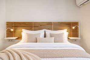 Un lit avec une tête de lit en bois, des lampes de chevet et une table de chevet.