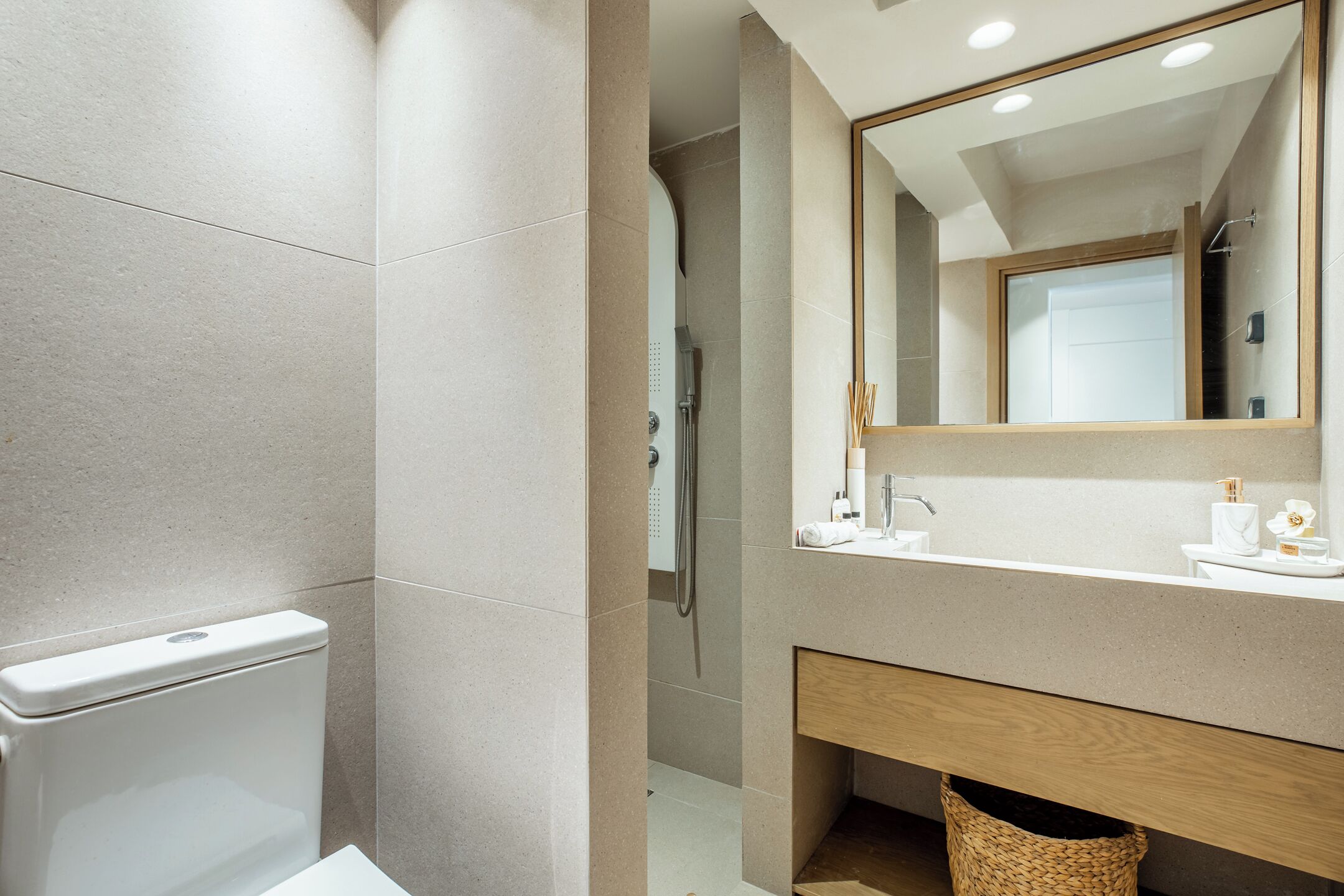 Un baño moderno con inodoro, ducha y zona de lavamanos.