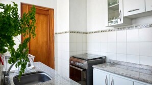A kitchen with white cabinets, a stainless steel stove, and a granite countertop. - Aparts4Days 2 Bedroom Apart San Isidro (Lima)