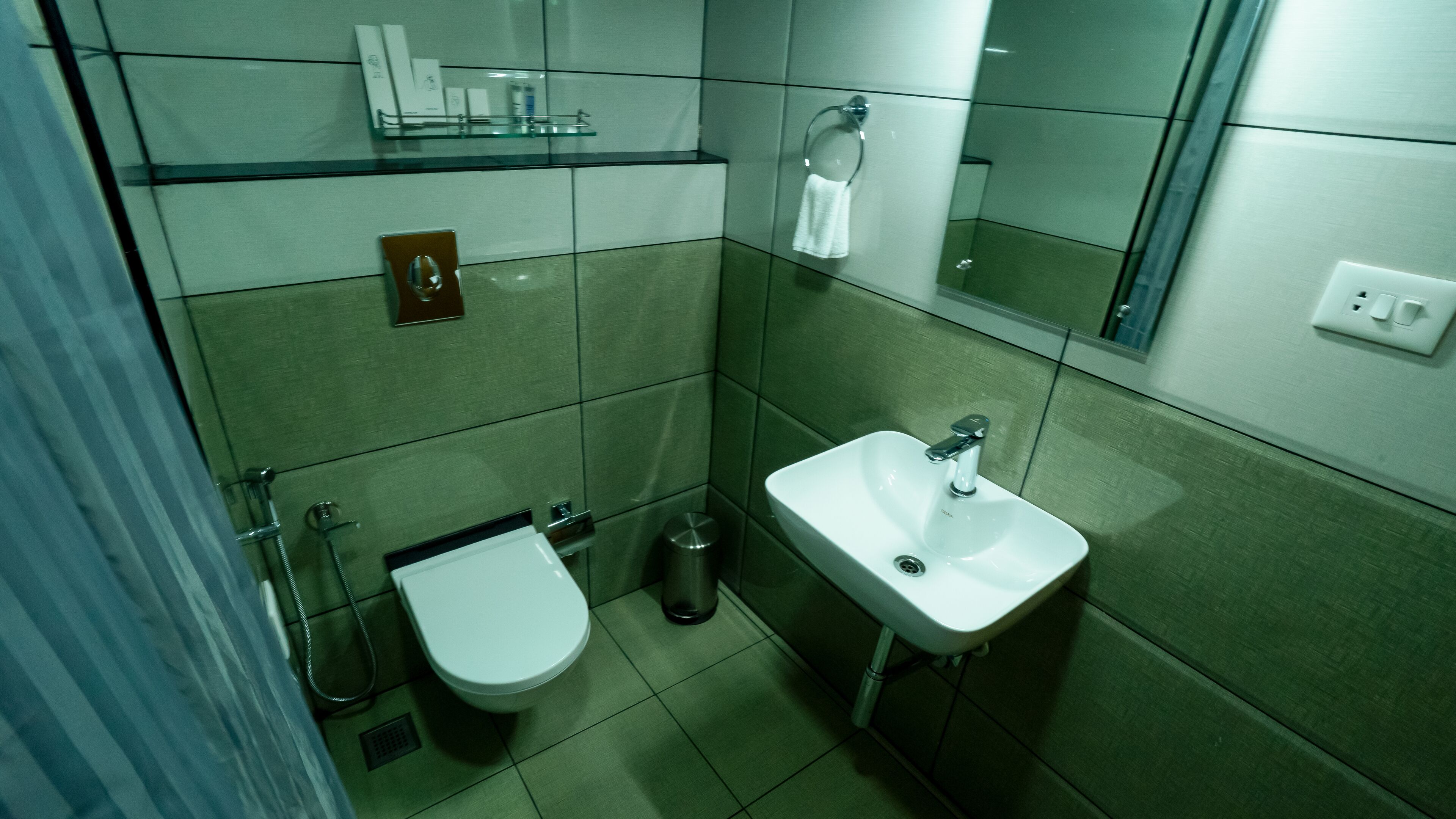A compact bathroom with a toilet, sink, and glass shower enclosure.