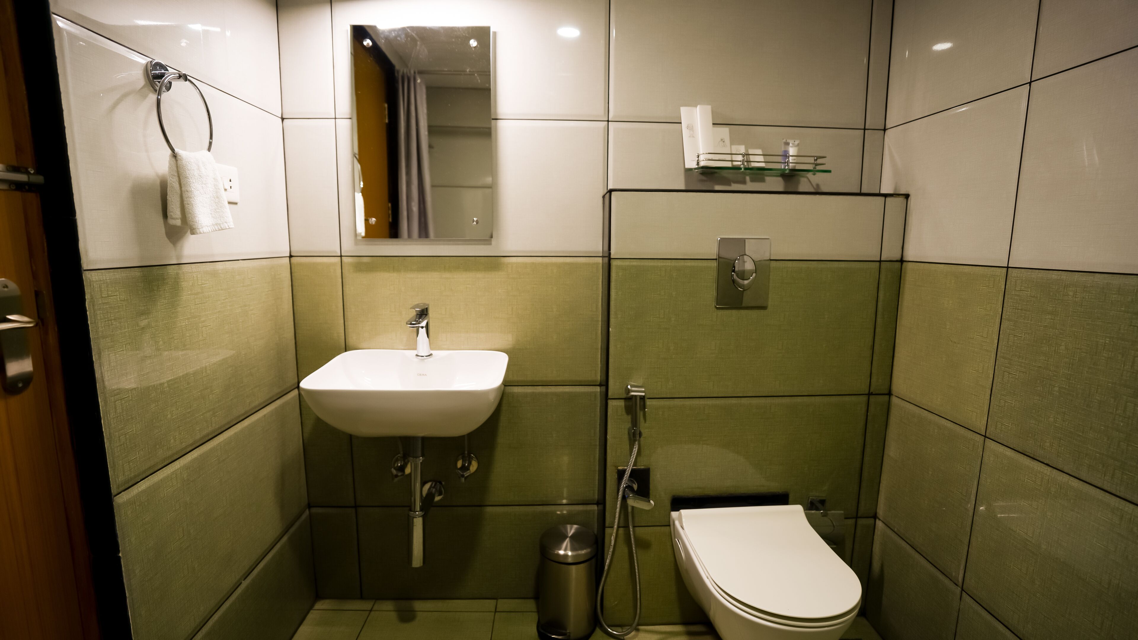 Une petite salle de bain compacte, équipée d’un lavabo, de toilettes et d’une douche.