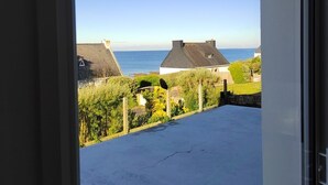 Un balcón con vista al mar y casas.