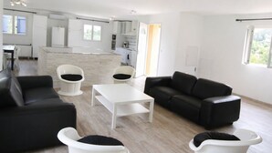 Ein modernes Wohnzimmer mit einer Couch, Sesseln und einem Couchtisch.