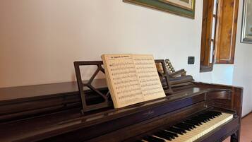 A piano with sheet music on it, placed in a room with wooden walls and framed pictures.