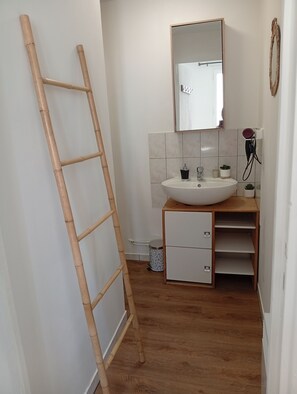 A bathroom with a wooden ladder, a white sink, a mirror, and a small potted plant. - Logis des Pivoines Maison Proche Le PAL (Trézelles)