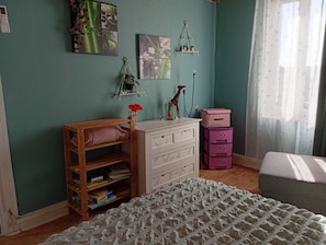 A room with a wooden bench, a white dresser, a pink storage unit, and a patterned bedspread. - Logis des Pivoines Maison Proche Le PAL (Trézelles)