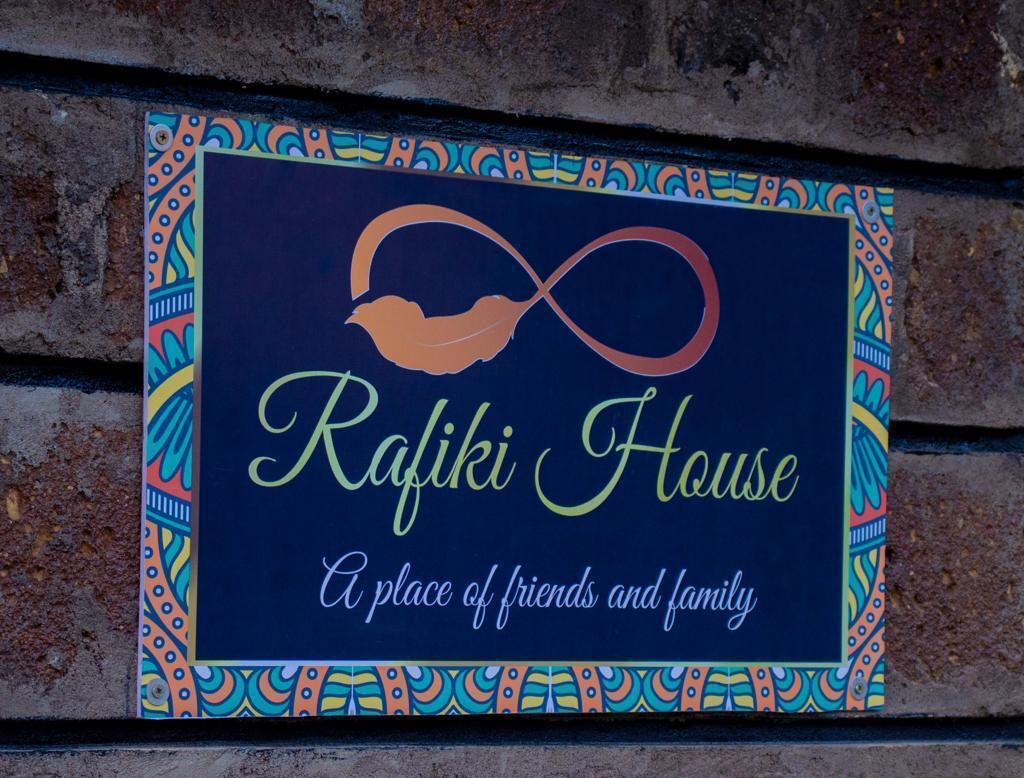 Segnale per Rafiki House, un luogo di amici e famiglia, con una cornice colorata e la sagoma di un uccello.
