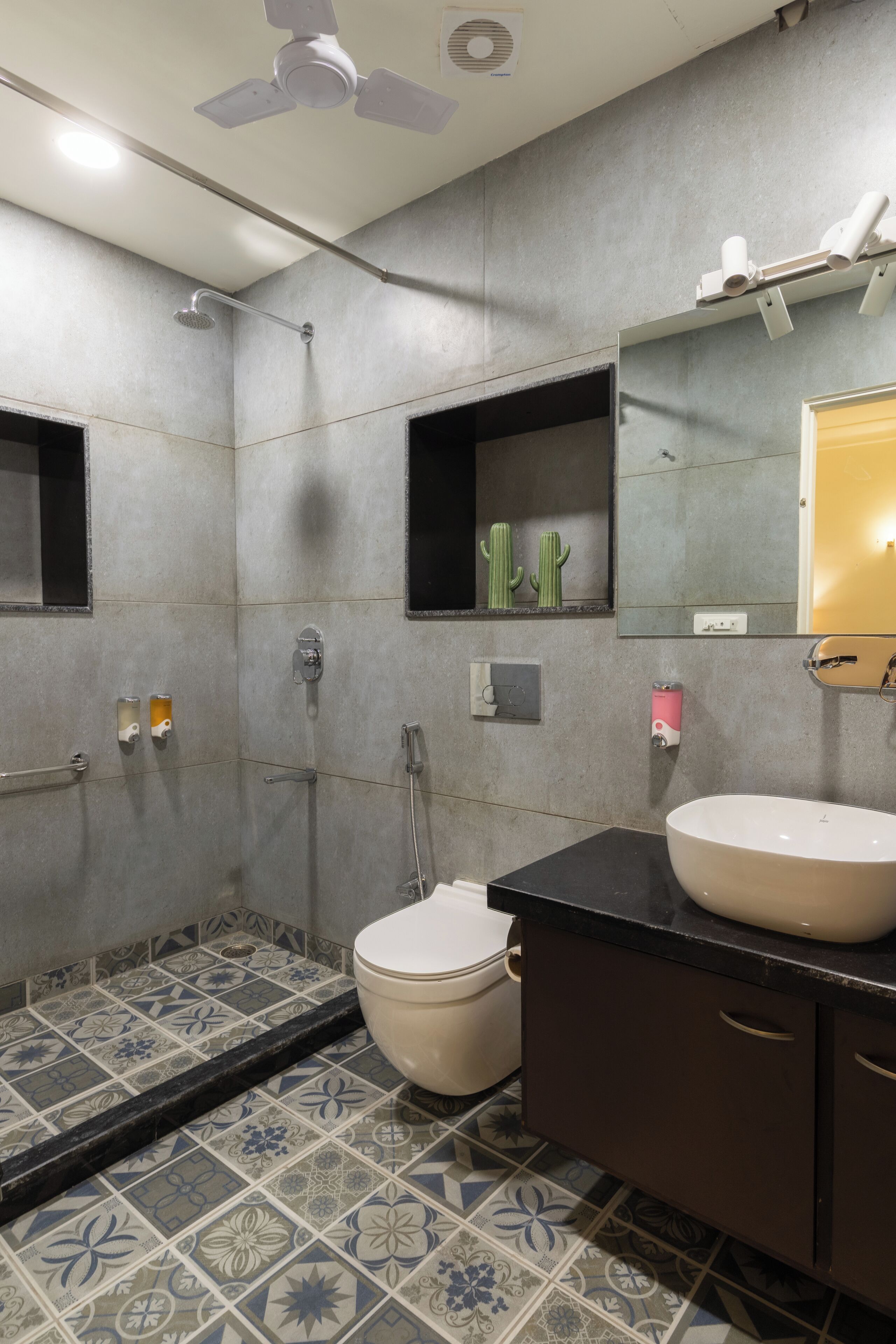 A bathroom with a shower, toilet, sink, and a ceiling fan.