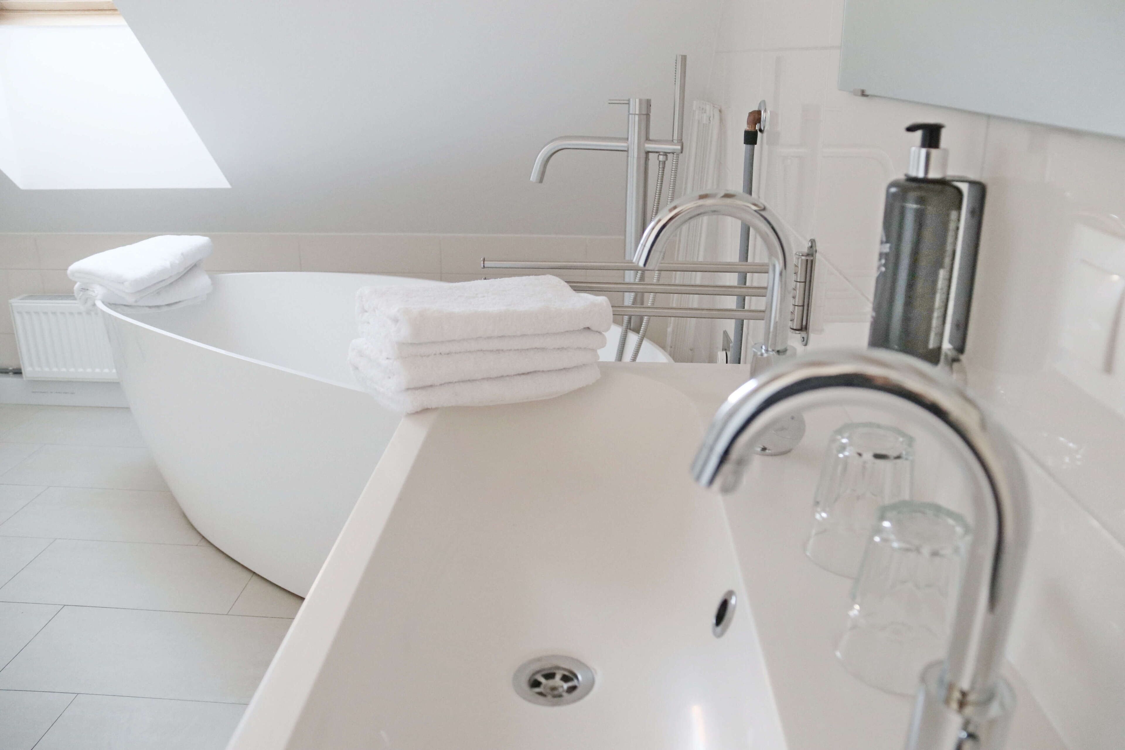 A modern bathroom with a freestanding bathtub, a large mirror, and a glass shower enclosure.