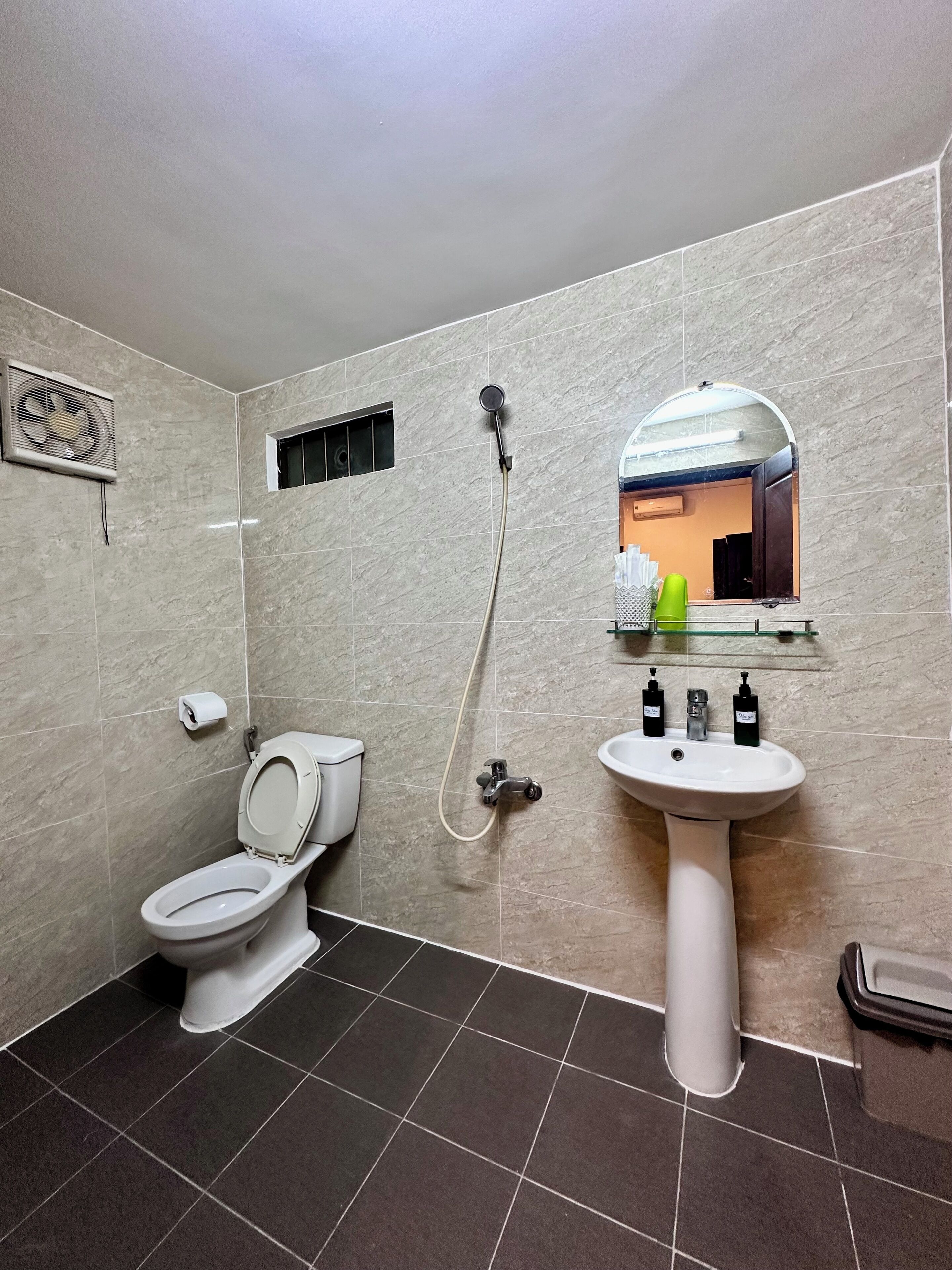 Un baño con inodoro, lavabo y ducha.