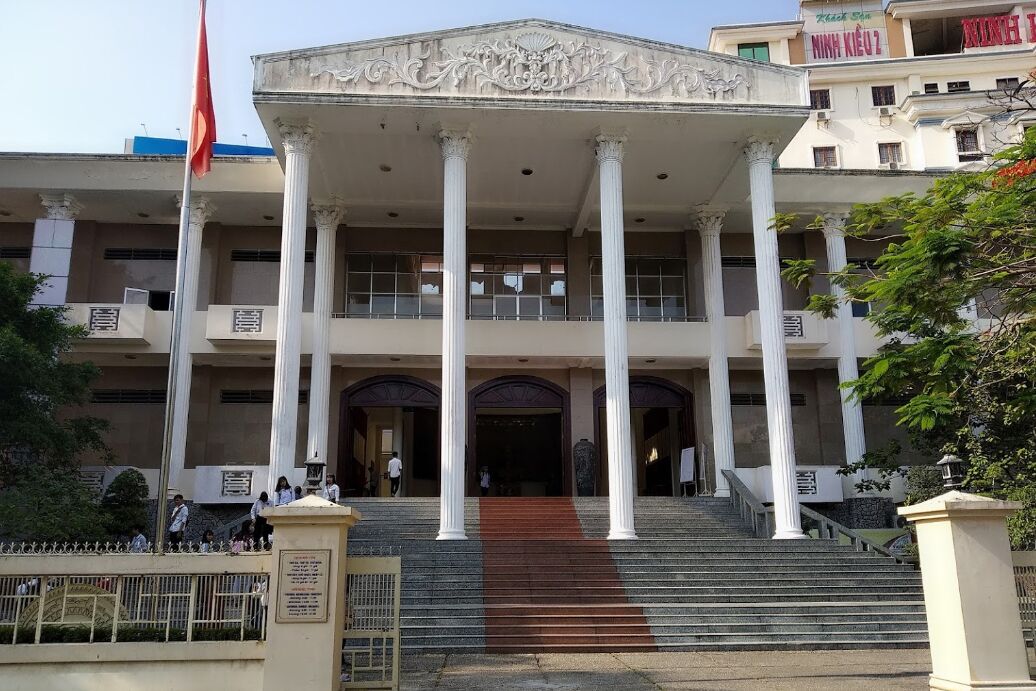 A building with a grand entrance, multiple columns, and a staircase leading up to the entrance.