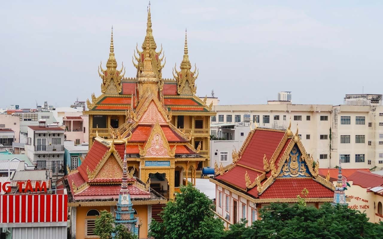 Een traditionele Thaïse tempel met versierde architectuur, waaronder wenteltrapvormige daken en gouden torentjes.