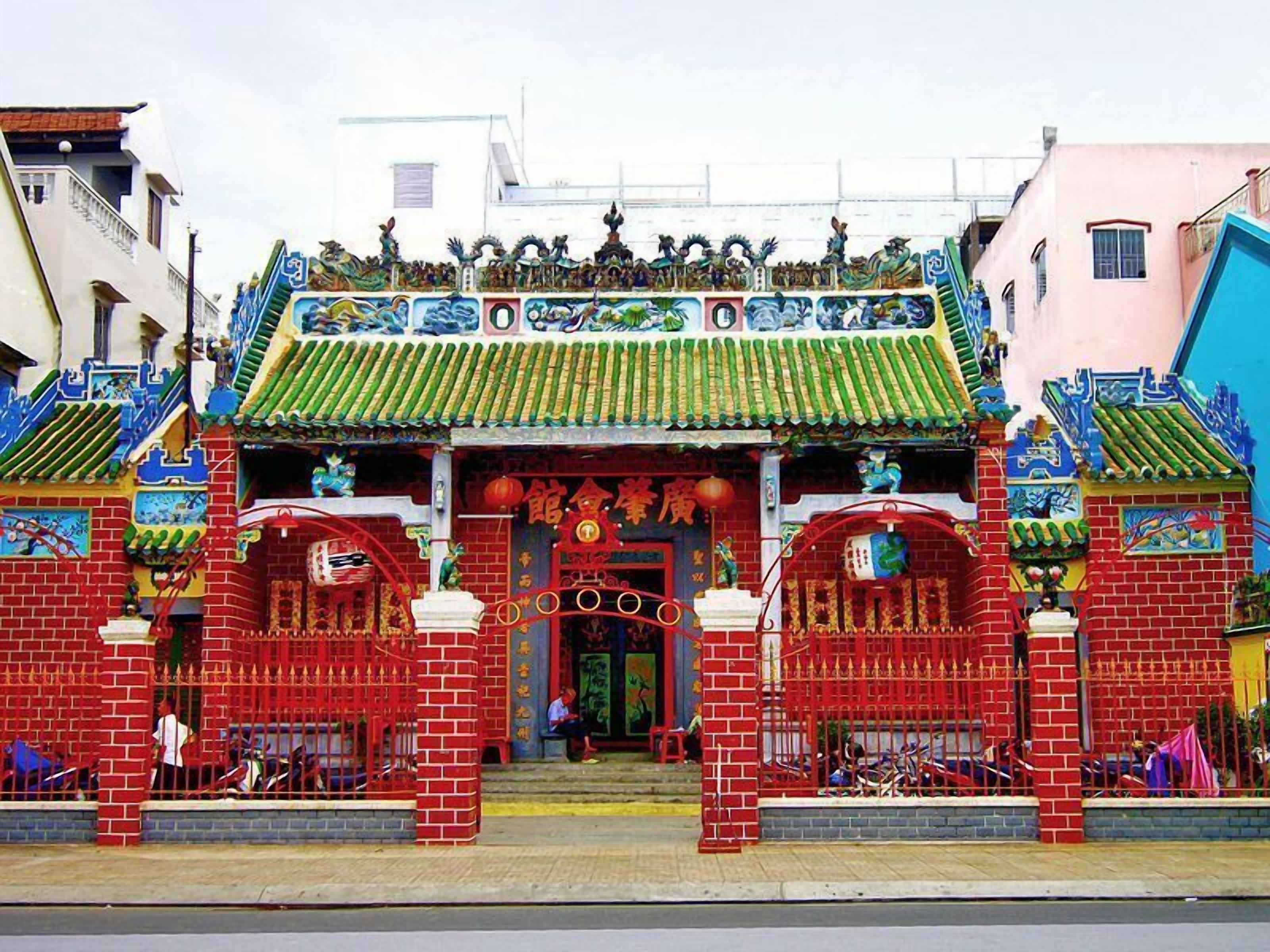 A traditional Chinese gate with intricate designs and a red brick facade.