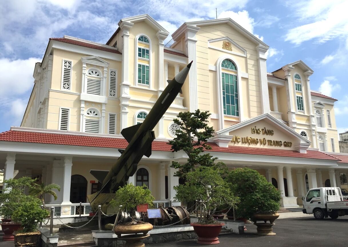 A large building with a prominent sculpture of a rocket in front.