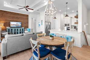 A modern kitchen with white cabinets, a stainless steel refrigerator, and a microwave.