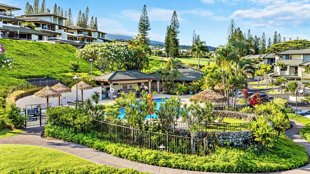A resort with a swimming pool, lush greenery, and multiple buildings.