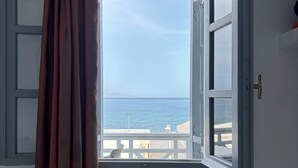 An open window with a view of the sea, a curtain, and a white wall. - Tarelis Beach Apartments & Studios (Santorini)