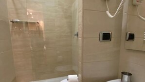Une salle de bain moderne avec une douche à parois de verre, des toilettes et un lavabo avec un miroir.
