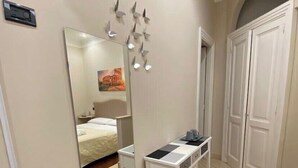 A hotel room with a bed, a bedside table, a mirror, and a wardrobe. - Rent rooms saint peter 2 (ROMA)
