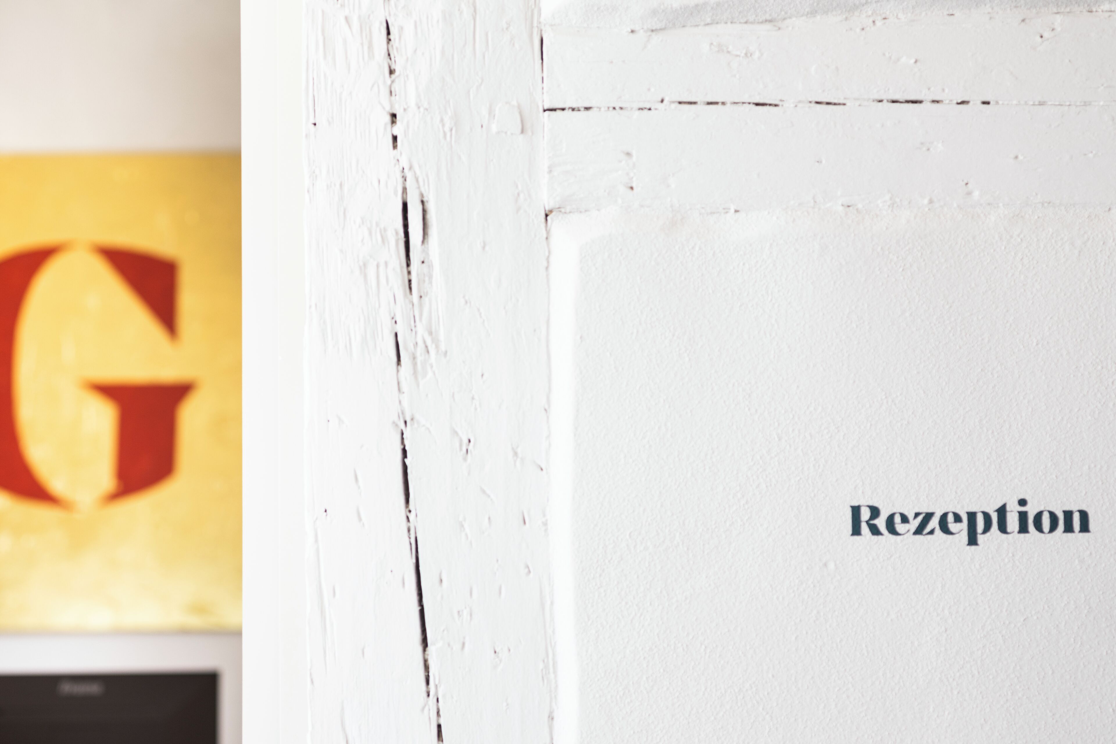 A white wall with the word "Rezeption" indicating a reception area.