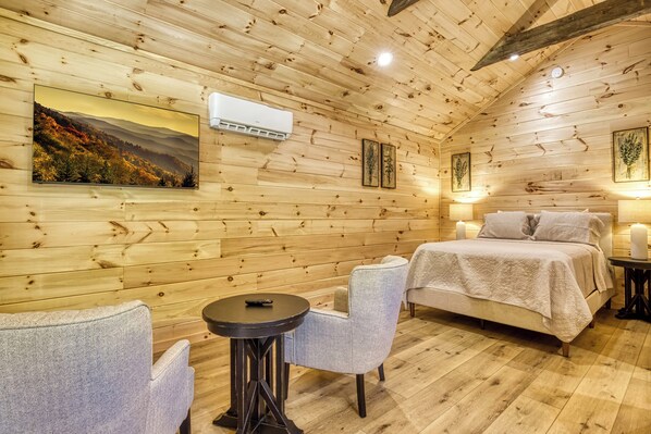 A cozy wooden room with a bed, two chairs, a small table, and a mounted TV. - Stary Night- Pickleball Court, Creek, WIFI, budget friendly (Cosby)
