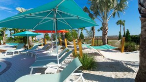 A beachside resort with lounge chairs and umbrellas, a hammock, and palm trees. - Epic 10BR Star Wars Villa • Theater • Pool (Davenport)