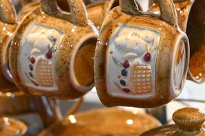 Ceramic mugs with handles, each featuring a unique design.