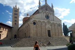A historic building with a prominent bell tower and a large arched entrance.