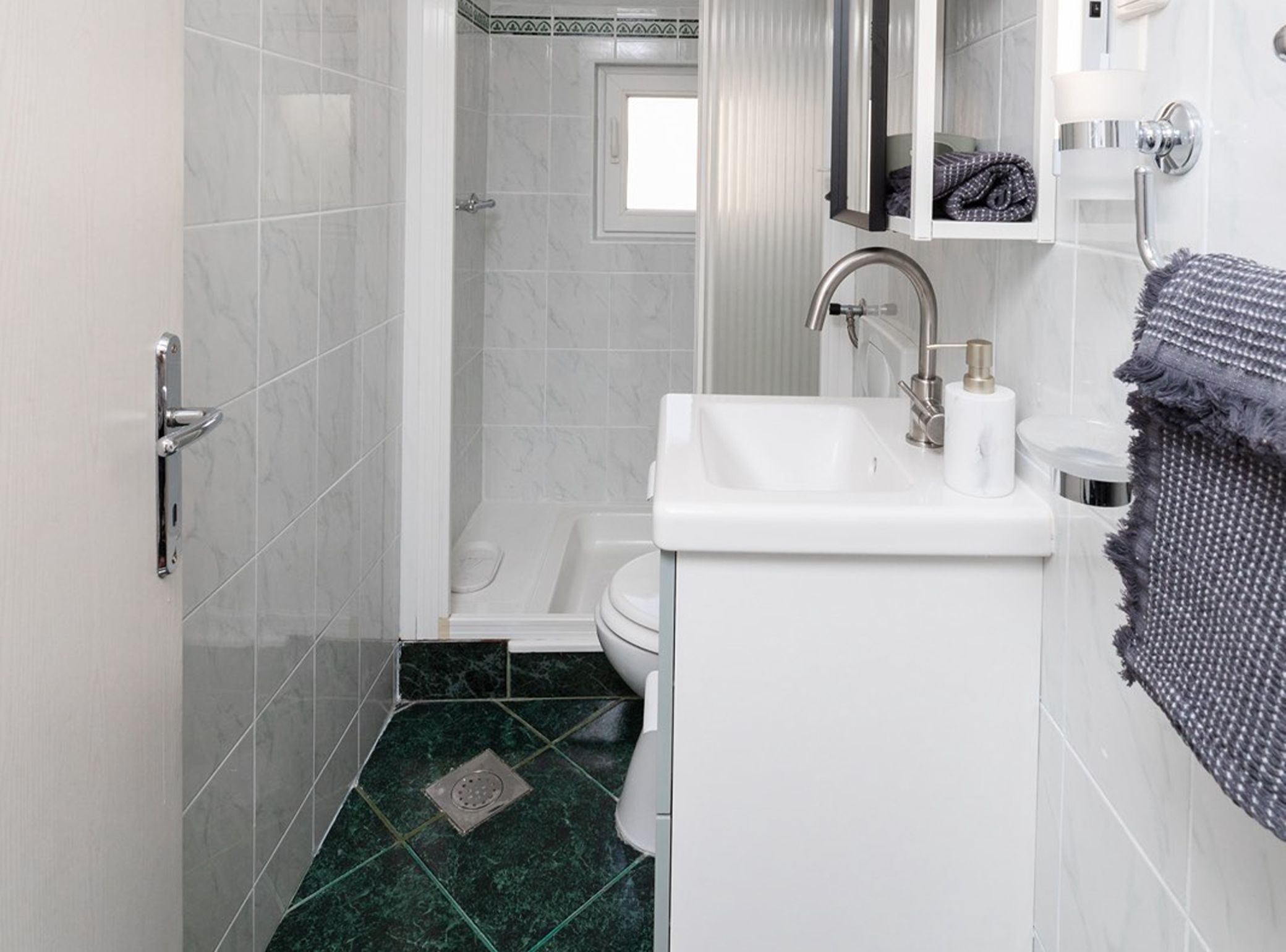 A bathroom with a white sink, a shower, and a toilet.