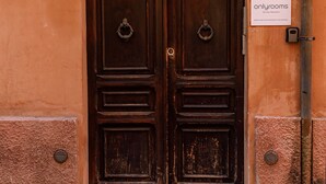 Une porte en bois à deux battants, ornée d’une poignée de porte en métal et d’une enseigne au-dessus.