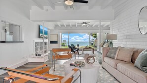 A modern living room with a view of the ocean, a sofa, a coffee table, and a chair. - Oceanfront Villa With Privet Beach Access ! (Fort Lauderdale)