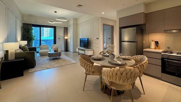 A modern apartment with a dining area, kitchen, and living room.