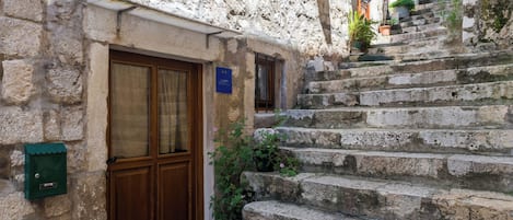A stone building with a wooden door and a sign indicating a sports facility.
