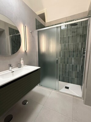 A modern bathroom with a glass shower enclosure, a large mirror, and a vanity with a sink. - Nabab-Napoli Bed and Breakfast (Naples)