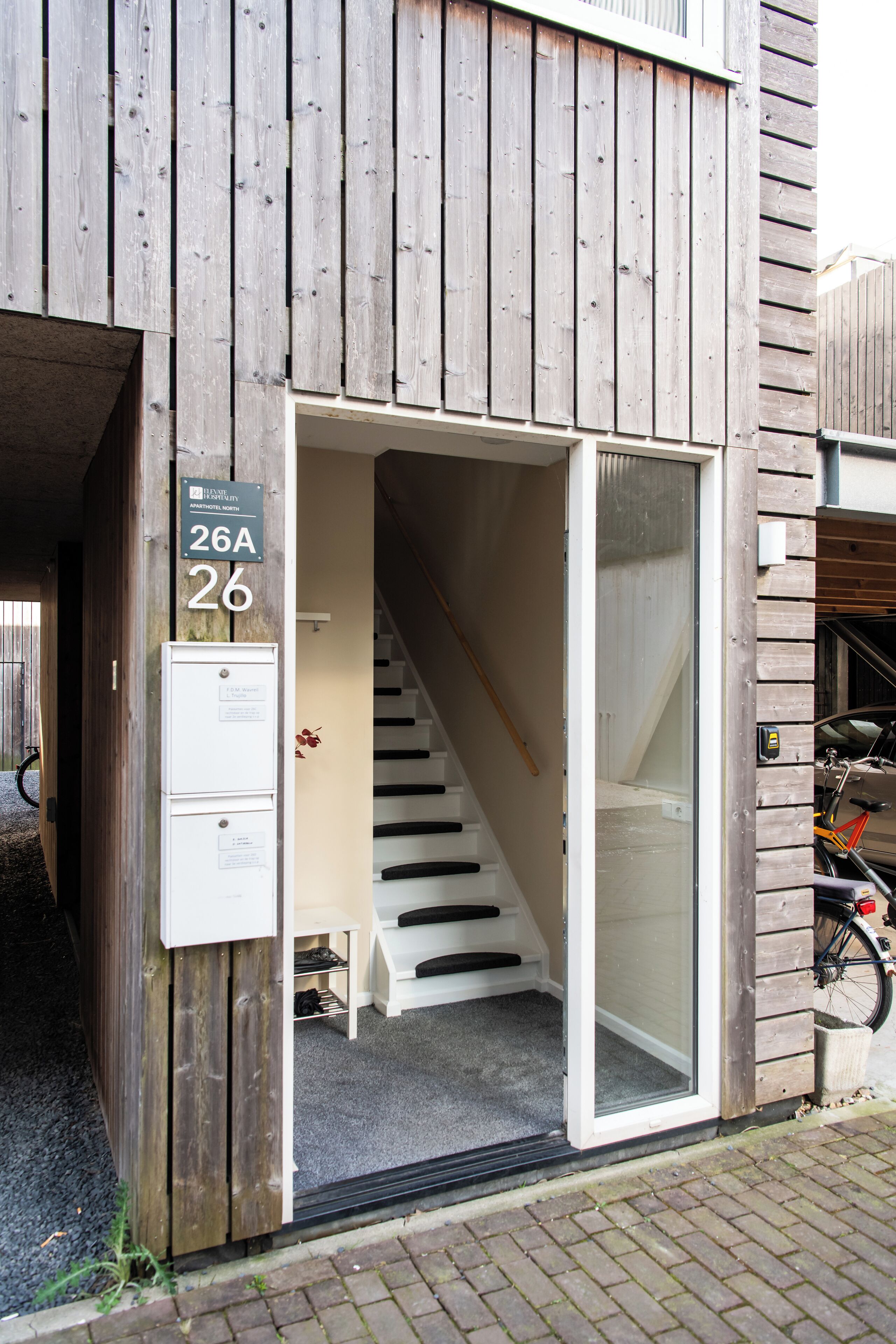 A wooden building with a sign indicating apartment number 26A.