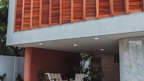 Een modern gebouw met een plat dak, grote ramen en een balkon met een hekwerk.