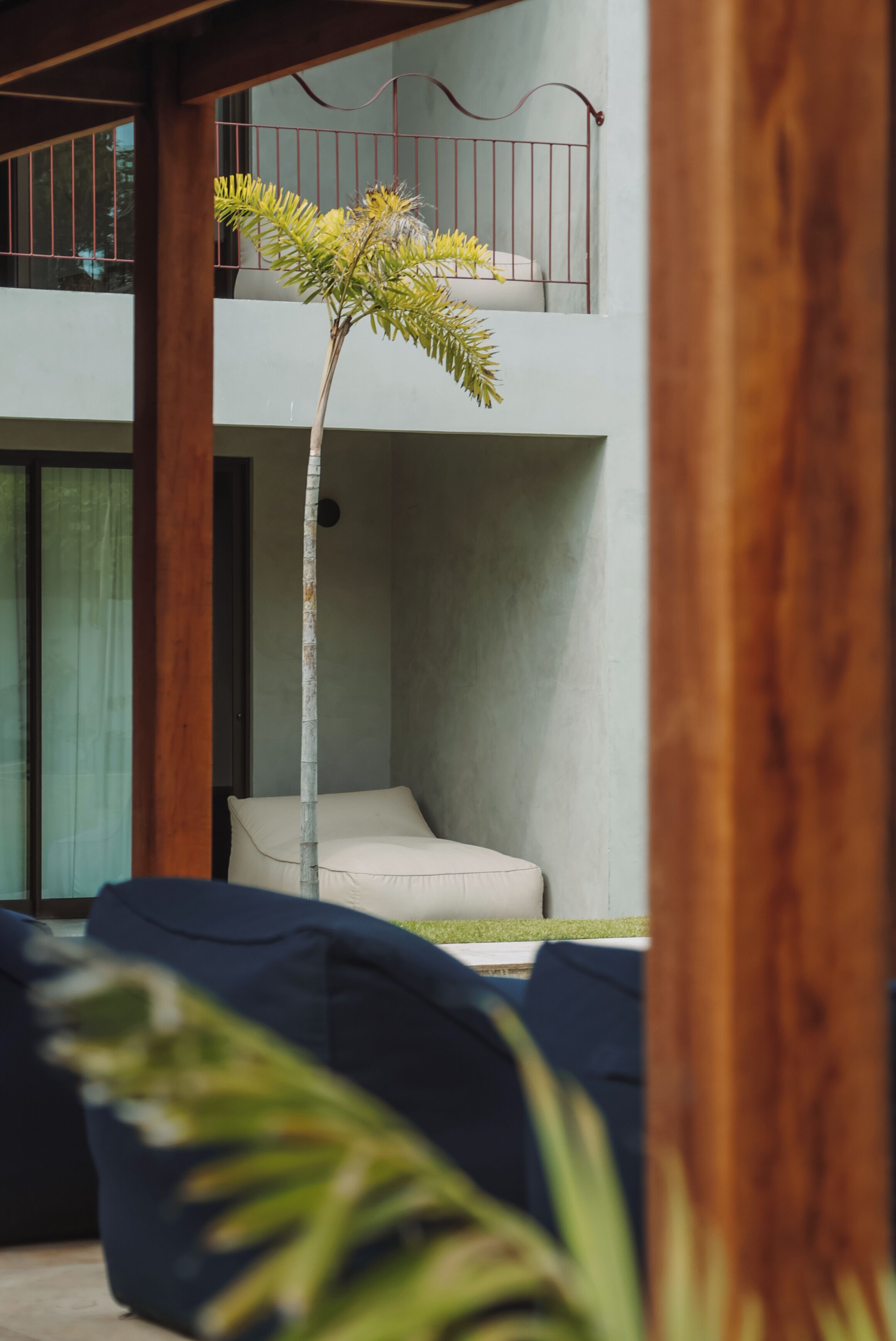 A modern outdoor seating area with a white chair and a small tree.