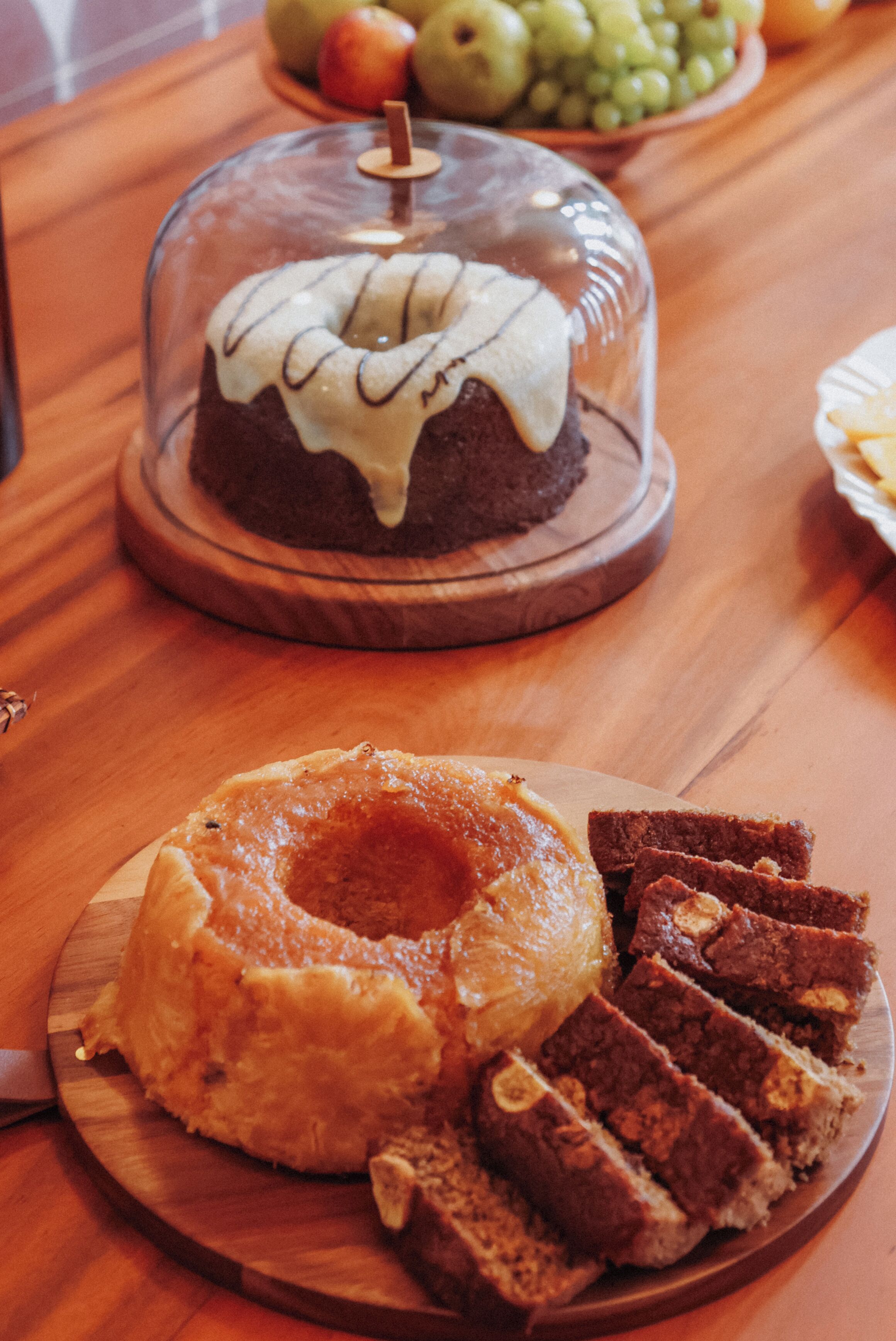 Una mesa de madera con un pastel cubierto y porciones de pastel.
