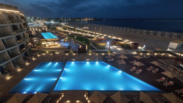 A resort with a large swimming pool, beachside lounge areas, and a view of the ocean. - Palma Bay Rotana Resort (El Alamein)