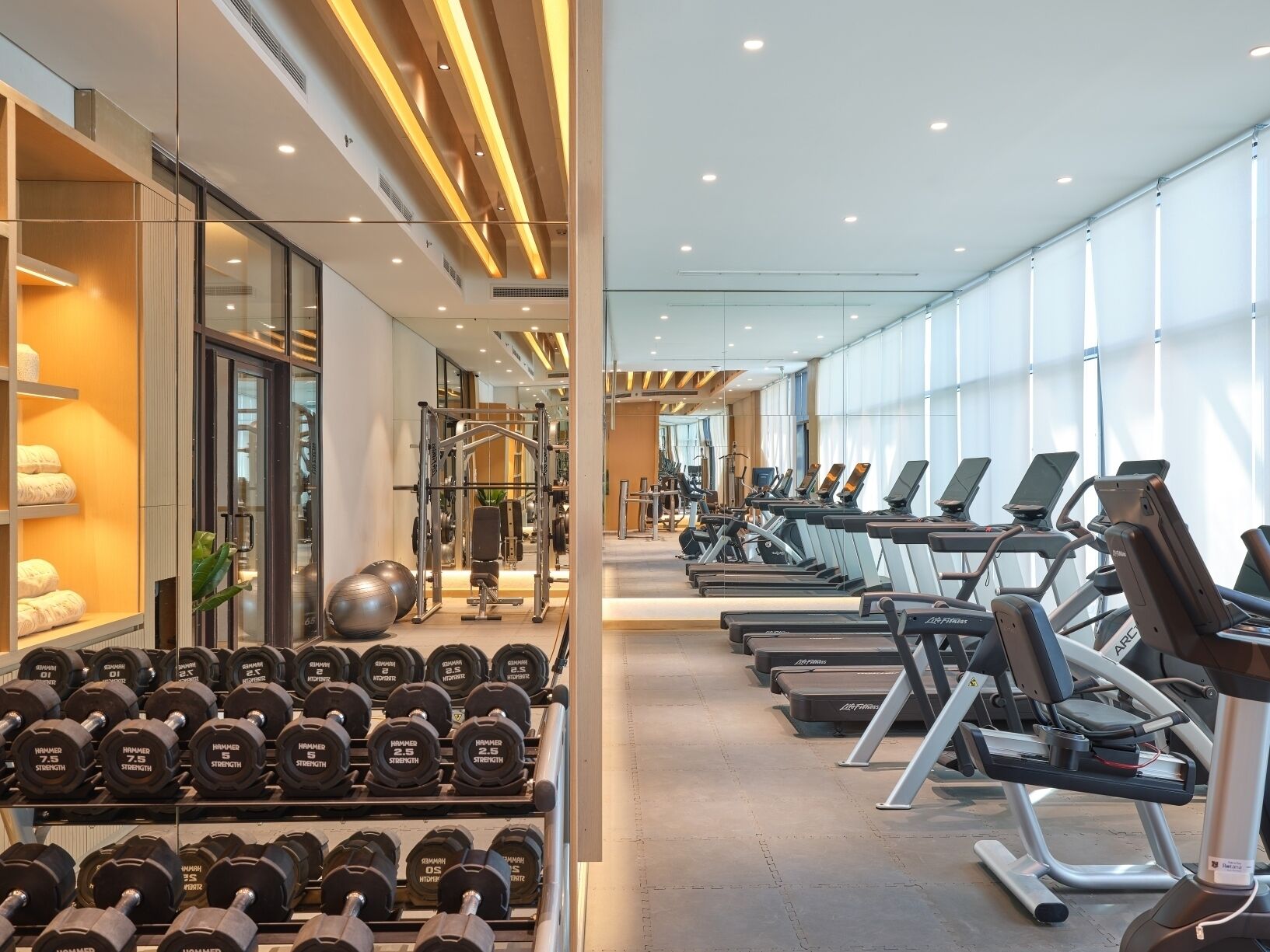 A gym with treadmills, dumbbells, and weight machines.