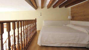 A bedroom with a wooden ceiling, a bed with white bedding, and a wooden railing. - Romantic Venetian Apartment with Grand Canal Views and High Ceilings (Venezia)