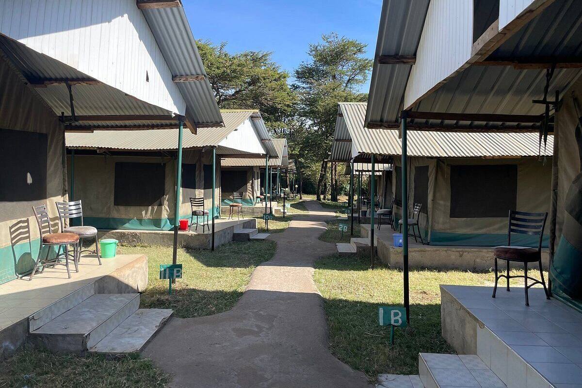 Un pasillo con varias habitaciones, cada una con un espacio de estar cubierto al aire libre y un sendero que atraviesa el centro.