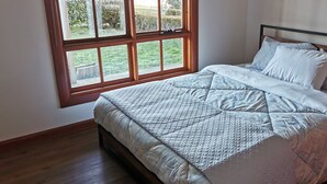 Une chambre à coucher avec un lit, une fenêtre et une vue sur l’extérieur.