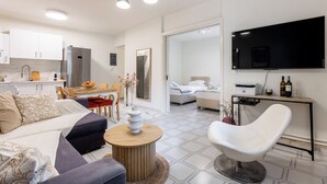 Ein modernes Wohnzimmer mit einer Couch, einem Couchtisch und einem an der Wand befestigten Fernseher.
